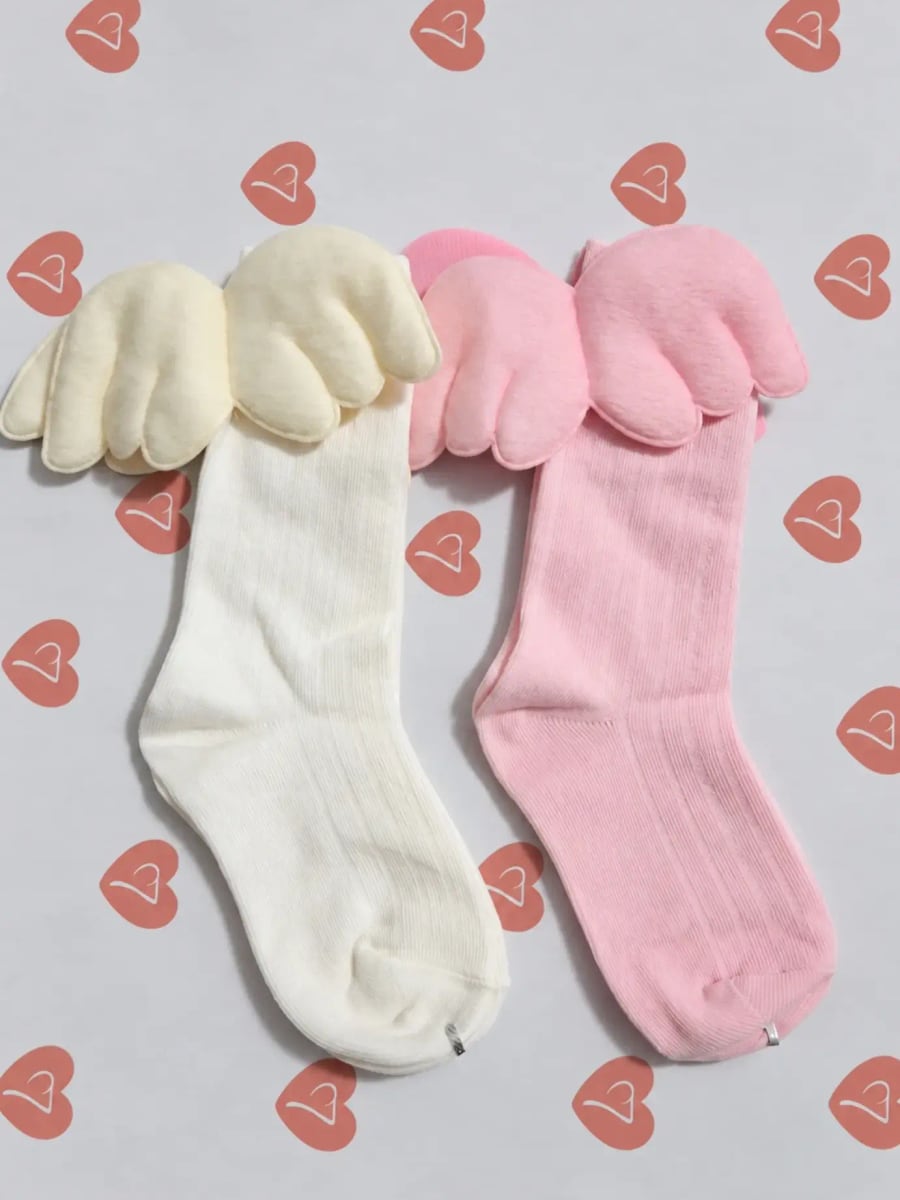 Duas meias malucas com asinhas, uma creme e uma rosa-clara